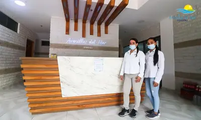 two people wearing masks standing in front of a counter at Arenillas del Mar in Tolú