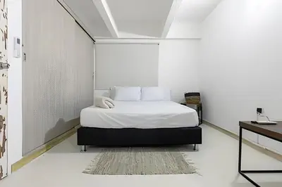 a white bedroom with a bed with white sheets and pillows at Laurdhomes Historic Center Plaza SantoDomingo 3Bth in Cartagena de Indias