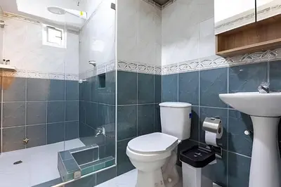 a bathroom with a toilet and a sink at Laurdhomes Historic Center Plaza SantoDomingo 3Bth in Cartagena de Indias