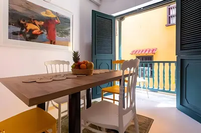 a dining room with a wooden table and chairs at Laurdhomes Historic Center Plaza SantoDomingo 3Bth in Cartagena de Indias