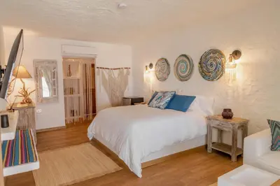 a bedroom with a white bed with blue pillows on it at Bora Bora Beach Club Cartagena in Isla Grande