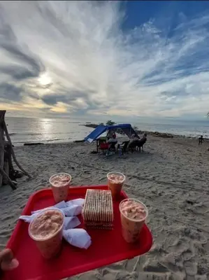 a tray of food on a beach with a tray of drinks at Jamadis in Tolú