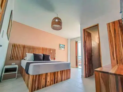 a bedroom with a large bed with a wooden headboard at Hotel Bahia Rada in Moñitos
