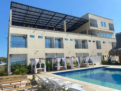 a hotel with a swimming pool and a building at Hotel Bahia Rada in Moñitos