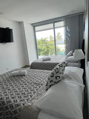 a bedroom with two beds and a large window at Sunny House in Cartagena de Indias