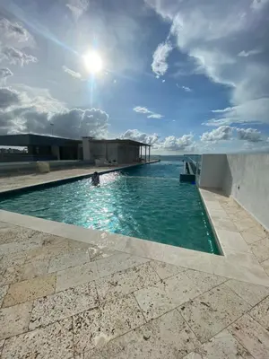 a swimming pool on top of a building with the ocean in the background at Sunny House in Cartagena de Indias