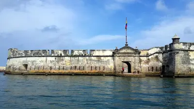 an old castle in the water with a person standing in the doorway at ORESCA Hostel in Cartagena de Indias