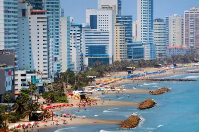 a beach in a city with people in the water at ORESCA Hostel in Cartagena de Indias
