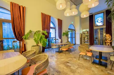a restaurant with tables and chairs and windows at Hotel Voilá Centro Histórico in Cartagena de Indias