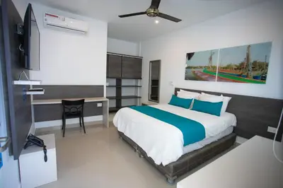a bedroom with a large bed and a desk at Hotel Poblado Coveñas in Coveñas