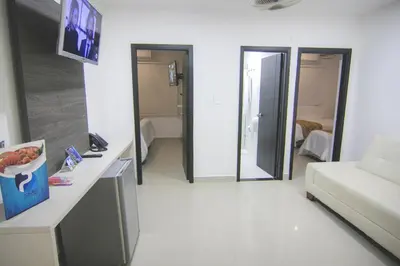 a white living room with a couch and a table at Hotel Poblado Coveñas in Coveñas