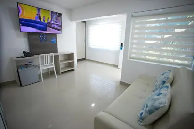 a living room with a couch and a tv at Hotel Poblado Coveñas in Coveñas