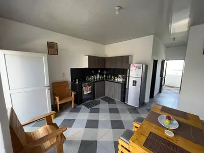 a kitchen with a table and a refrigerator at Amiri in Puerto Colombia