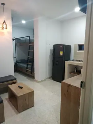 a room with a kitchen with a refrigerator and a table at zara's apartamento en coveñas in Coveñas