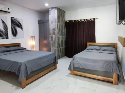 a bedroom with two beds and a tv on the wall at zara's apartamento en coveñas in Coveñas