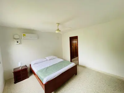 a small bedroom with a bed and a night stand at MADILI DEL MAR in Santiago