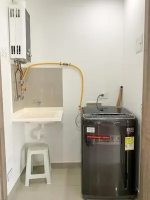 a small kitchen with a trash can and a stool at Oceanview Escape Pool, Jacuzzi & Gym in Bocagrande in Cartagena de Indias