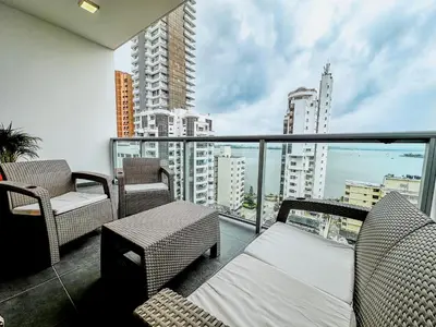 a balcony with chairs and a view of the city at Oceanview Escape Pool, Jacuzzi & Gym in Bocagrande in Cartagena de Indias
