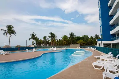 a swimming pool with lounge chairs and a resort at Magico Apartamento Frente al Mar 3 Habitaciones PAZ151 in Coveñitas