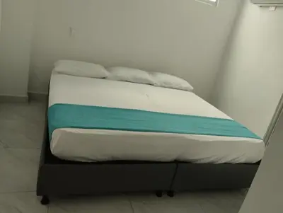 a bed with a blue and white blanket on it at Sky view hotel tolu in Tolú