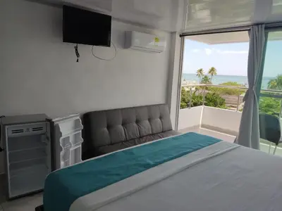 a bedroom with a bed and a view of the ocean at Sky view hotel tolu in Tolú