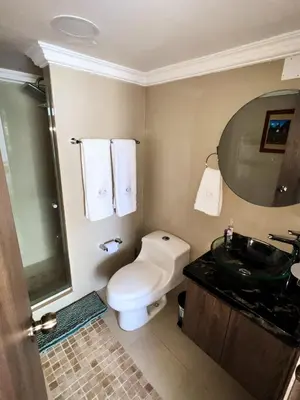 a bathroom with a toilet and a sink and a mirror at Polanco Residences Tocagua Cartagena - Colombia in Cartagena de Indias