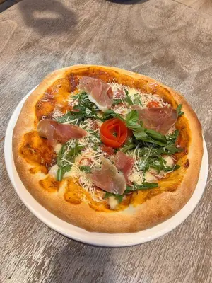 a pizza on a white plate on a table at Espetacular vista mar y playa in Cartagena de Indias
