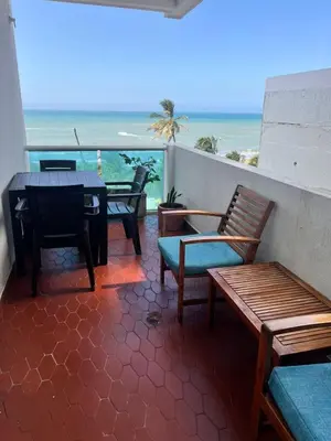 a balcony with benches and a table and the beach at Espetacular vista mar y playa in Cartagena de Indias