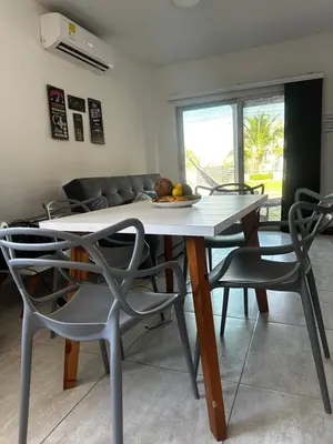 a table and chairs in a living room with a couch at Cabaña pescador de colores in Coveñas