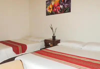 a room with two beds and a painting on the wall at Portoazul Casa de Playa in Puerto Colombia