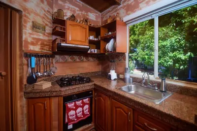 a kitchen with a sink and a stove and a window at Portoazul Casa de Playa in Puerto Colombia