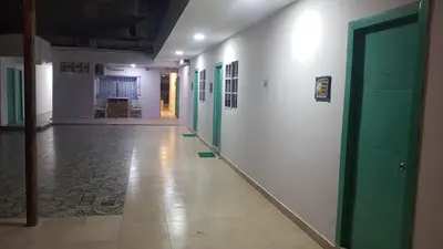 an empty hallway with green doors and a tile floor at Hotel CastilloMar in Cartagena de Indias