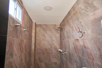 a bathroom with a shower with wooden tiles at Passarela Hospedaje in Cartagena de Indias