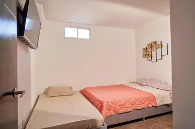 a small bedroom with two beds and a window at Passarela Hospedaje in Cartagena de Indias