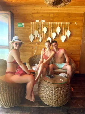a group of three people sitting in wicker chairs at Hotel Prana Beach in Baru