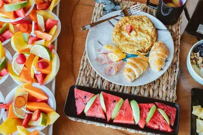 a table topped with plates of food and fruit at Hotel Prana Beach in Baru