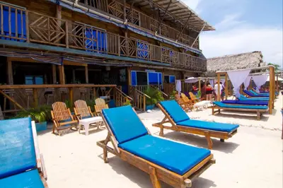 a group of blue chairs on a beach at Cabaña Coral Azul in Playa Blanca