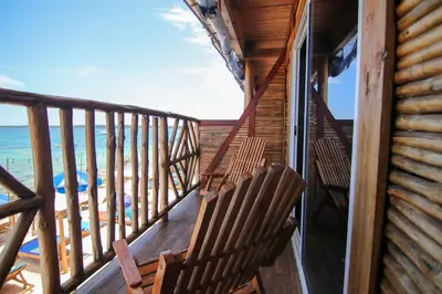 a balcony with two chairs and the beach at Cabaña Coral Azul in Playa Blanca