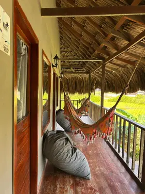 a hammock on the porch of a house at Kite Eco House Salinas del rey in Salina de Rey