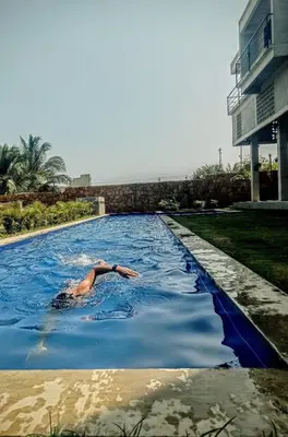 a man swimming in a swimming pool next to a building at BREES in Santa Veronica