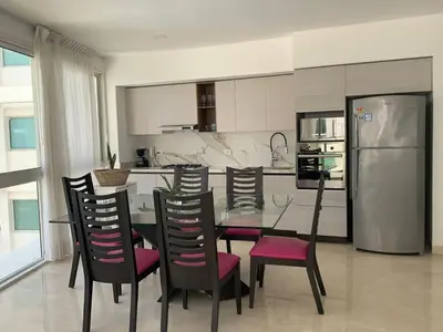 a kitchen with a table and chairs and a refrigerator at Morros 3 - Vista y salida directa al mar in Cartagena de Indias