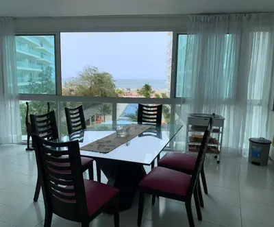a dining room with a table and chairs and a large window at Morros 3 - Vista y salida directa al mar in Cartagena de Indias