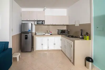 a kitchen with white cabinets and a stainless steel refrigerator at Hermosa Cabana con Piscina 3 Habitaciones MC21 in Coveñitas