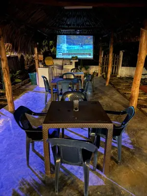 a dining room with tables and chairs and a television at Hotel Paradise in Isla Fuerte