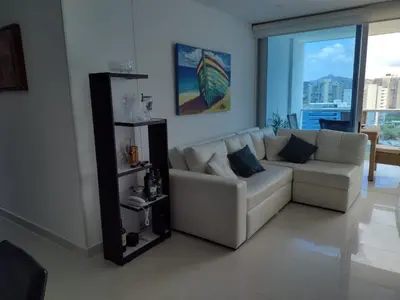 a living room with a white couch and a large window at APARTAMENTO BELLO HORIZONTE in Santa Marta