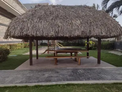 a picnic table under a thatched umbrella at APARTAMENTO BELLO HORIZONTE in Santa Marta