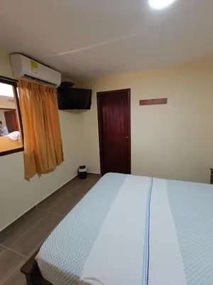 a bedroom with a large bed and a window at Hotel Costa mar in Barranquilla
