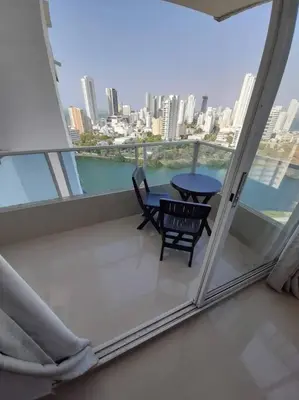 a balcony with a table and chairs and a view of the city at APARTAMENTO CON VISTA AL MAR CARIBE PISO 19 - Espectacular in Cartagena de Indias