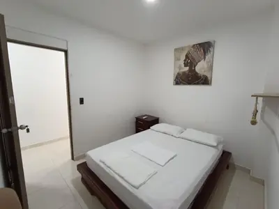 a white room with a bed and a mirror at Cabaña la Isla-Coveñas in Coveñas
