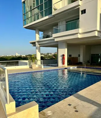 a building with a swimming pool in front of a building at APTO DUPLEX Bella vista Piscina y buena ubicación in Cartagena de Indias